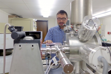 Aaron Satkoski, a scientist in the Department of Geoscience at UW–Madison, with the mass spectrometer used to measure isotopes in rocks from South Africa. DAVID TENENBAUM 