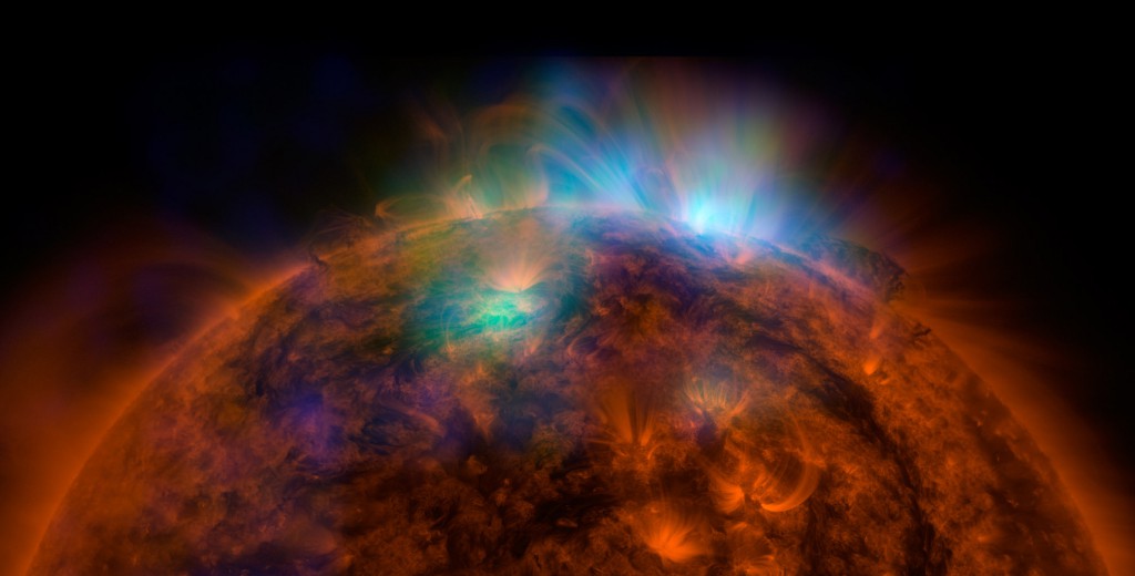 X-rays streaming off the sun appear in tones of blue and green in an image from NASA’s Nuclear Spectroscopic Telescope Array spacecraft, or NuSTAR, overlaid on a picture acquired by NASA’s orbiting Solar Dynamics Observatory (SDO).